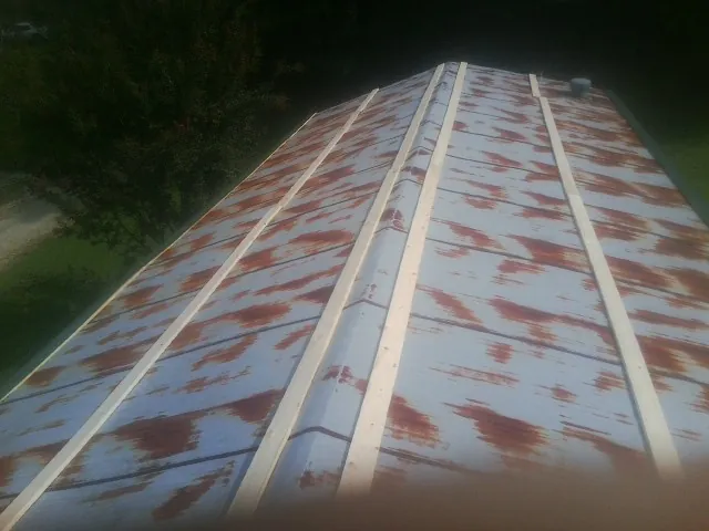 Rusted metal roof panels with new wood purlins before replacement — Storm Damage Roof Repair in El Cerrito by Roofing Brothers